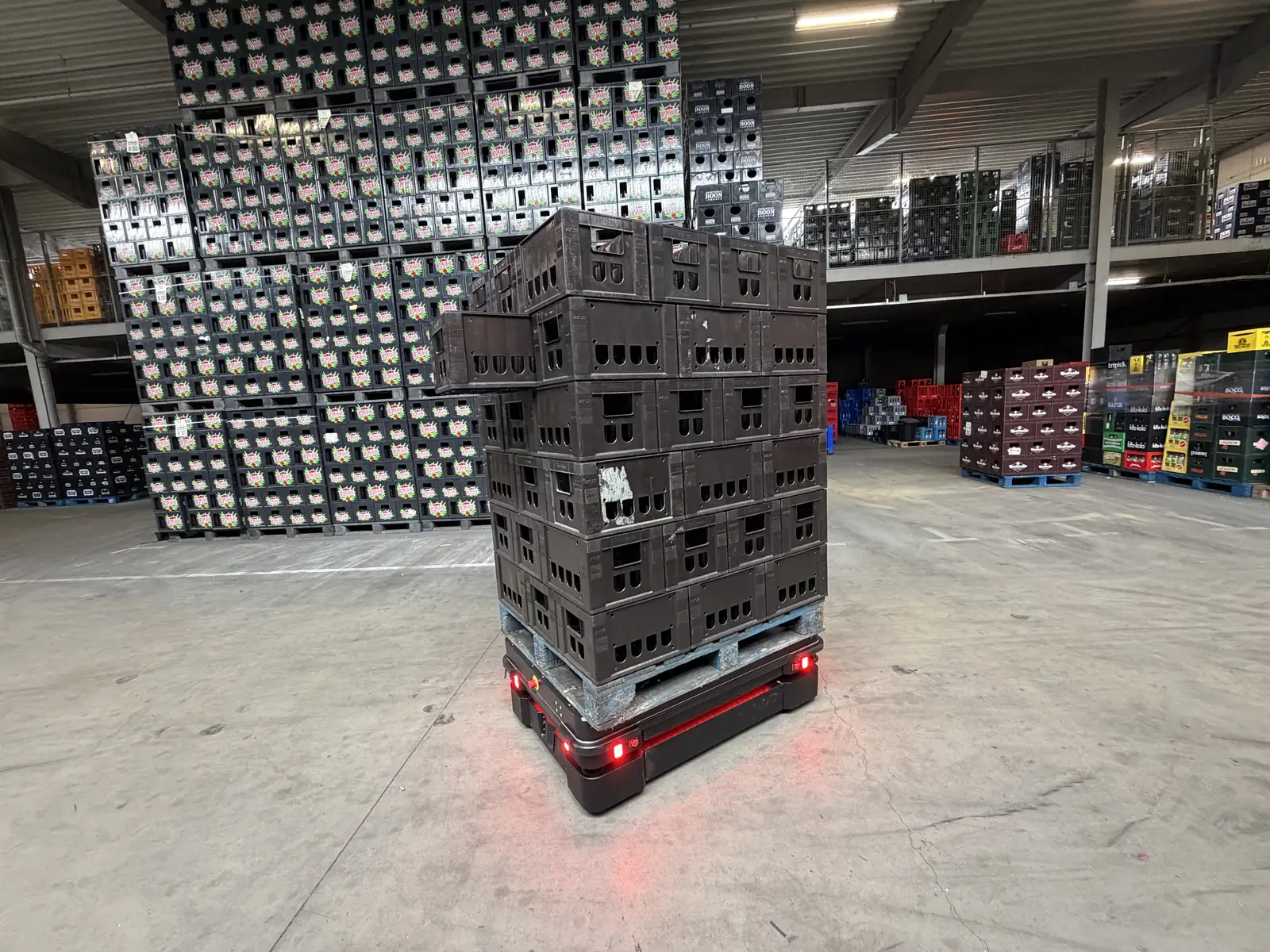 A Flow+ AMR transporting beverage crates through a distribution warehouse